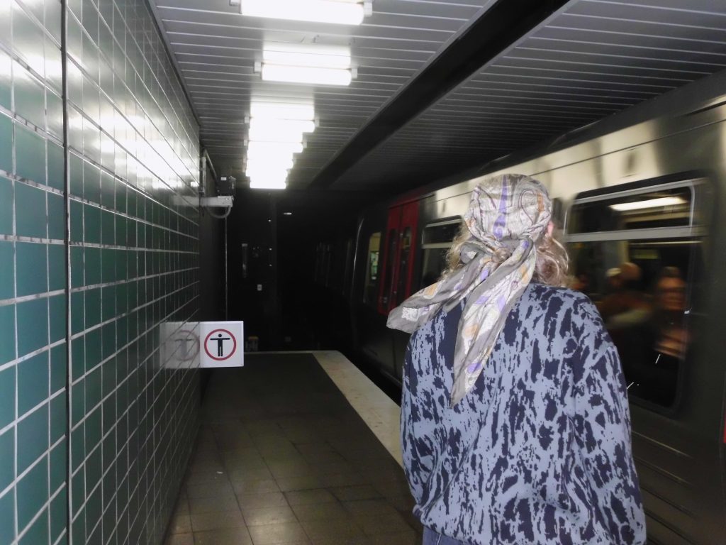 Eine Person in einem U-Bahnhof und eine einfahrende U-Bahn